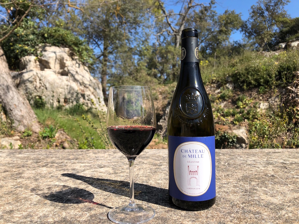 bouteille de vin rouge et verre servi et posé sur une pierre dans un cadre naturel