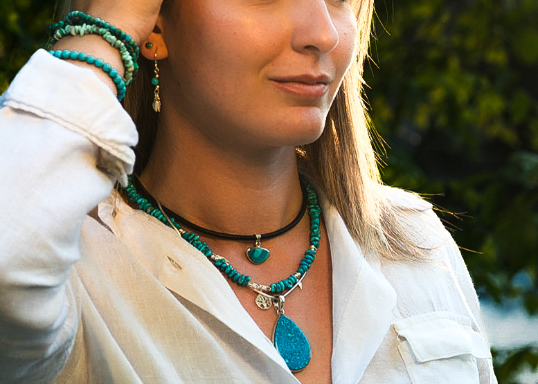 jeune femme arborant plusieurs bijoux dans les tons bleus et verts