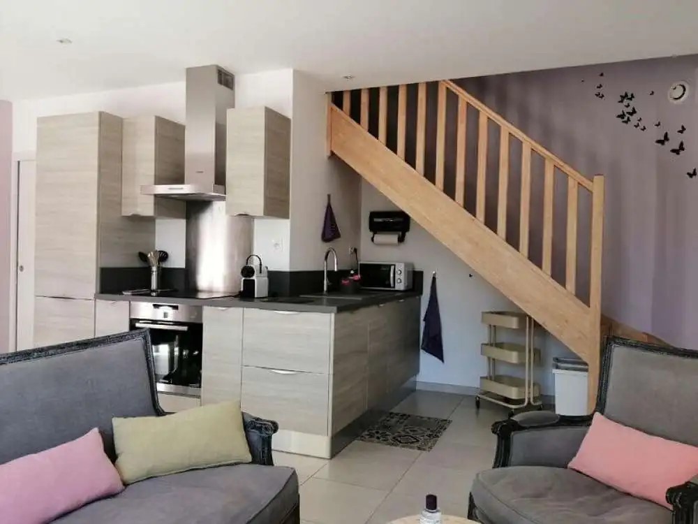 vue de l'intérieur avec le salon et la cuisine, un escalier mène à l'étage