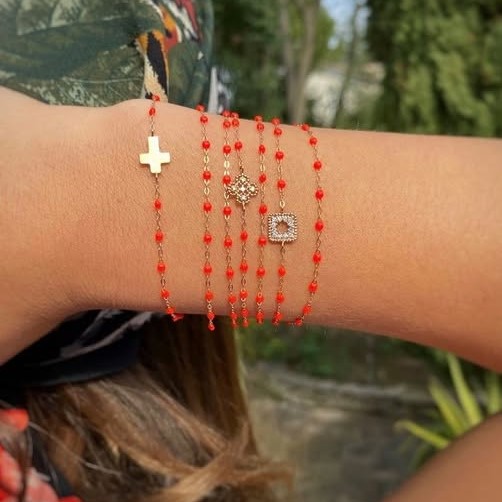 Bracelets fins et colorés, ornés de petits pendentifs symboliques, pour un style délicat et solaire.