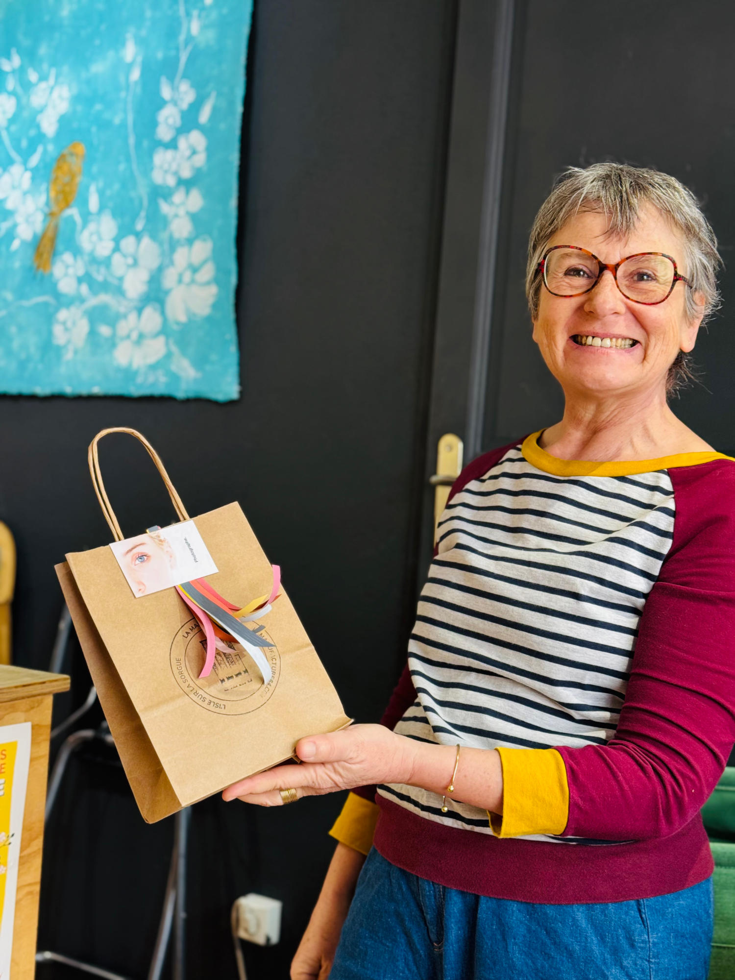 femme souriante présentant fièrement un sac