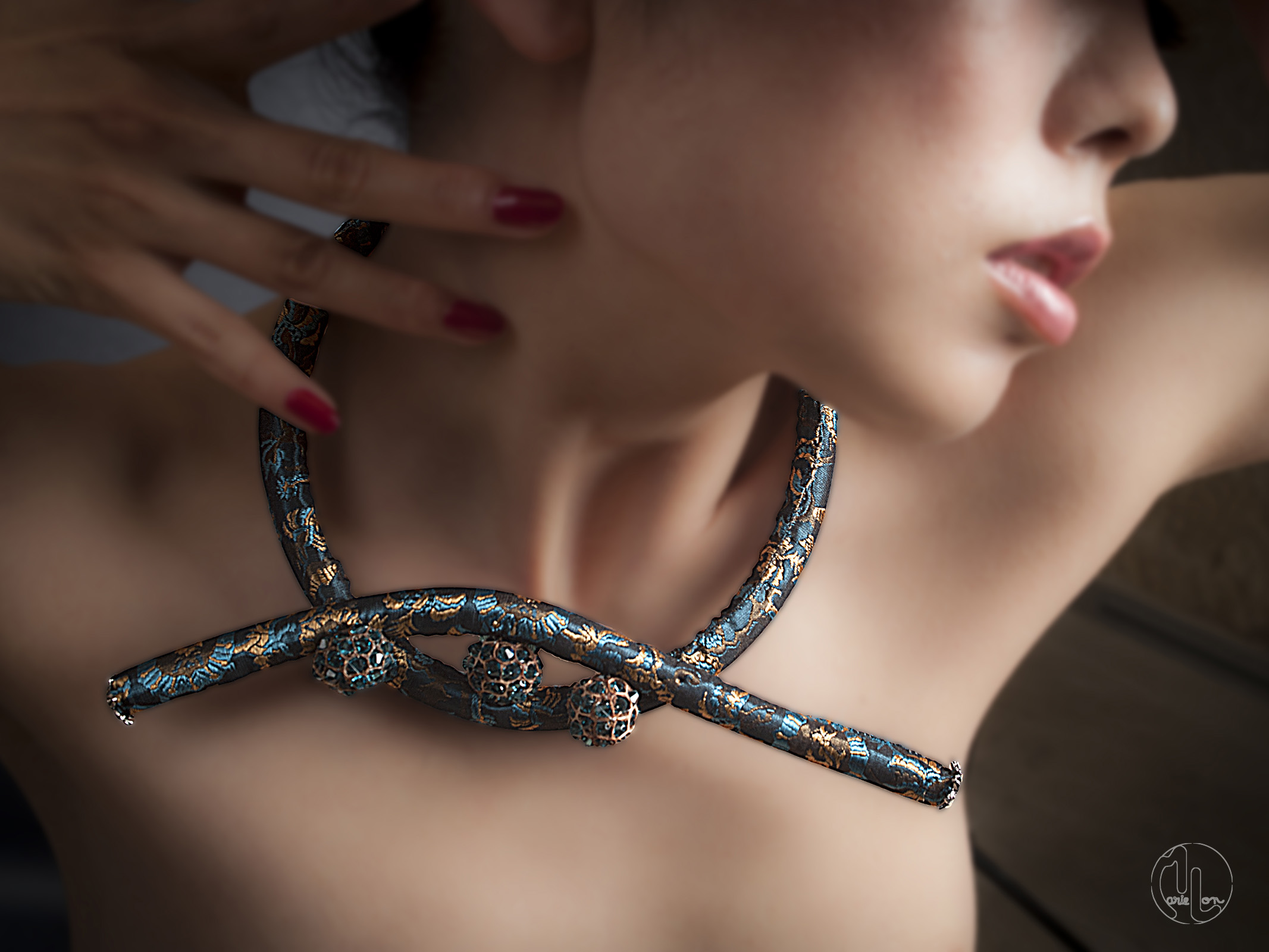 Collier textile bleu or et noir porté au cou d'une femme et main avec doigts vernis rouge