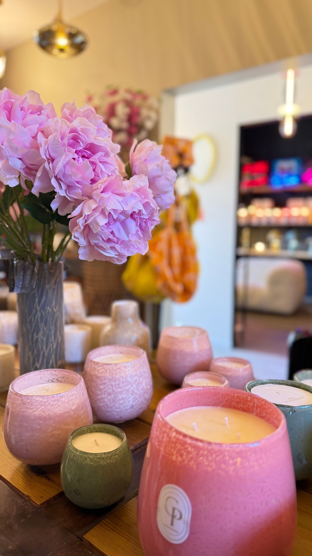 bouquet de pivoine rose artificielles avec bougies artisanales en pots en verre de couleurs rose et blanc et vert et blanc