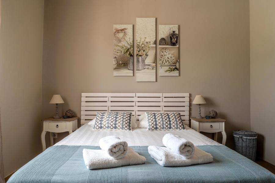 Chambre beige dessus de lit bleu ciel triptyque au mur et 2 tables de chevet bois blanc