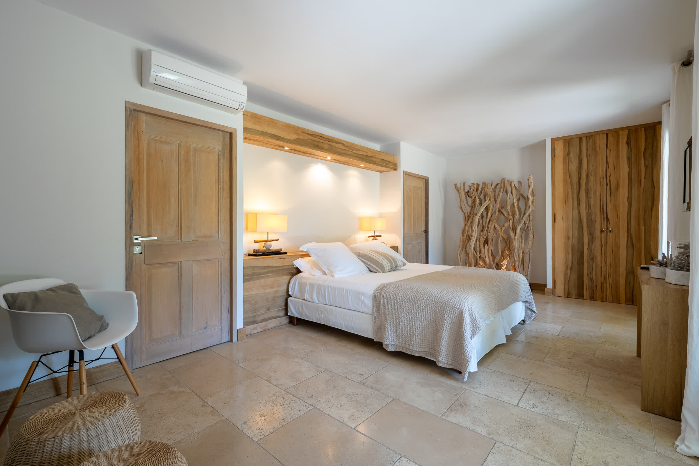 Chambre spacieuse et lumineuse au style épuré, avec lit double, matériaux naturels et décoration chaleureuse mêlant bois clair et tons neutres.