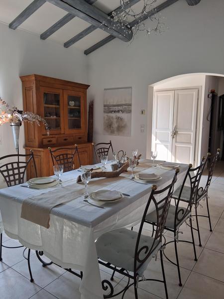 Salon, salle à manger blanche avec table et chaises en fer forgé