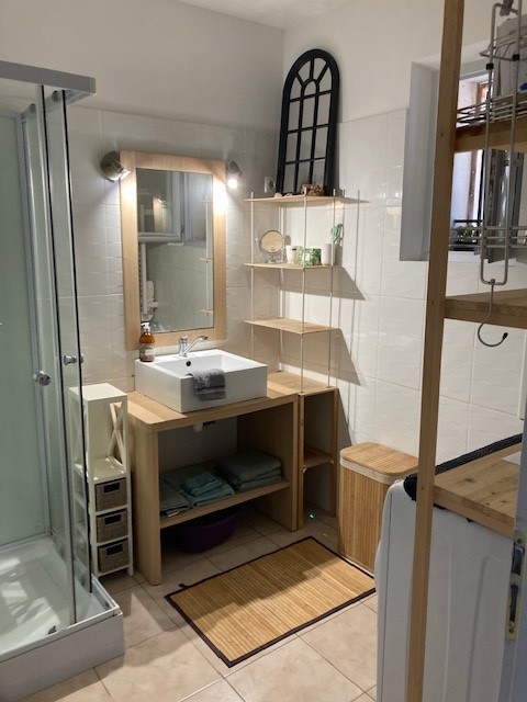 Salle de Bain avec une douche blanche et bois.