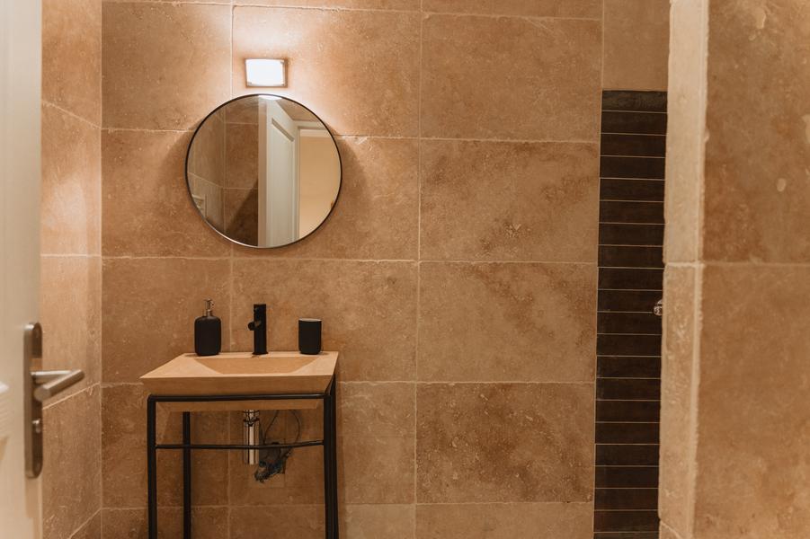 Salle de bain avec vasque simple et miroir