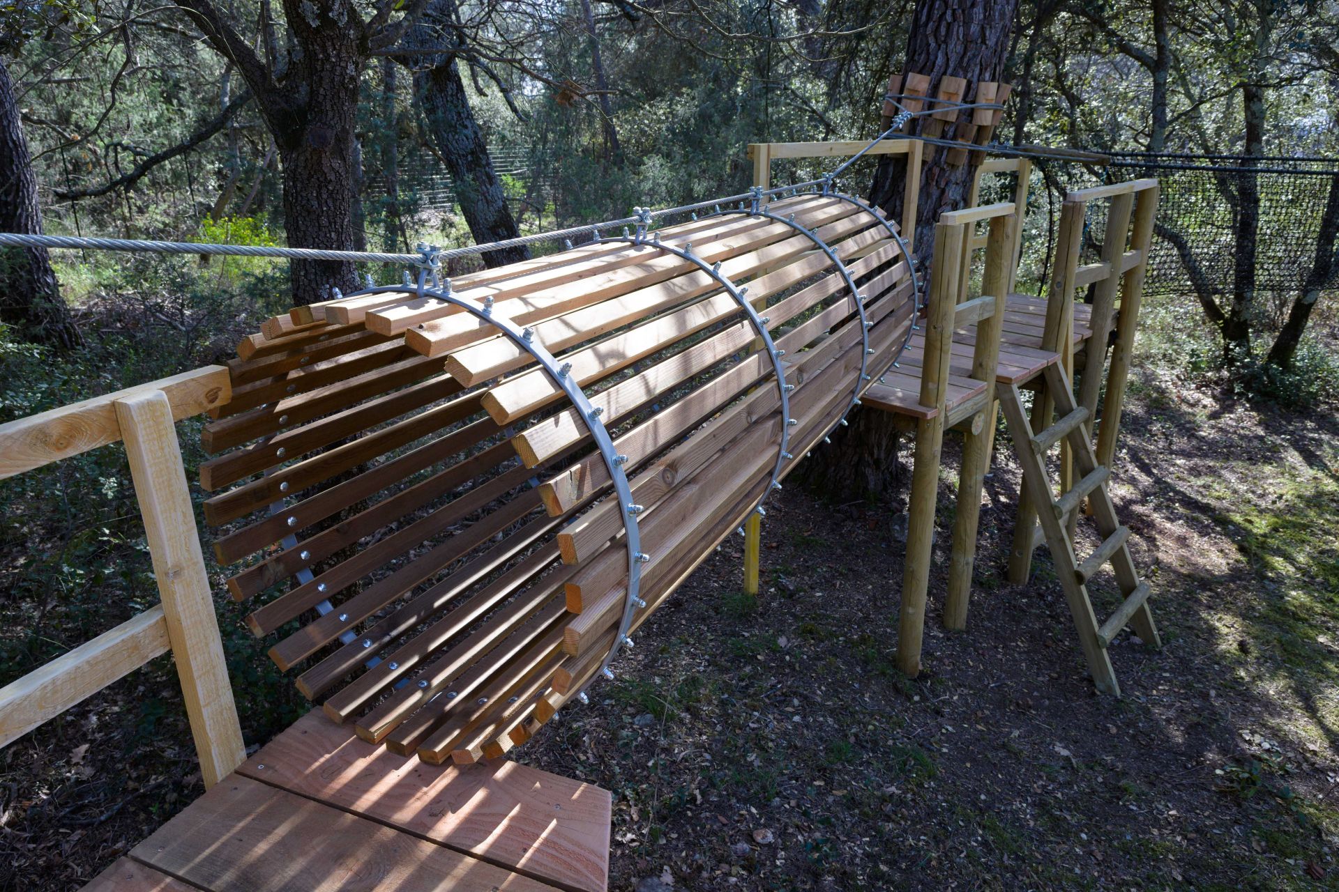 accrobranche avec en premier plan un cylindre en bois à traverser