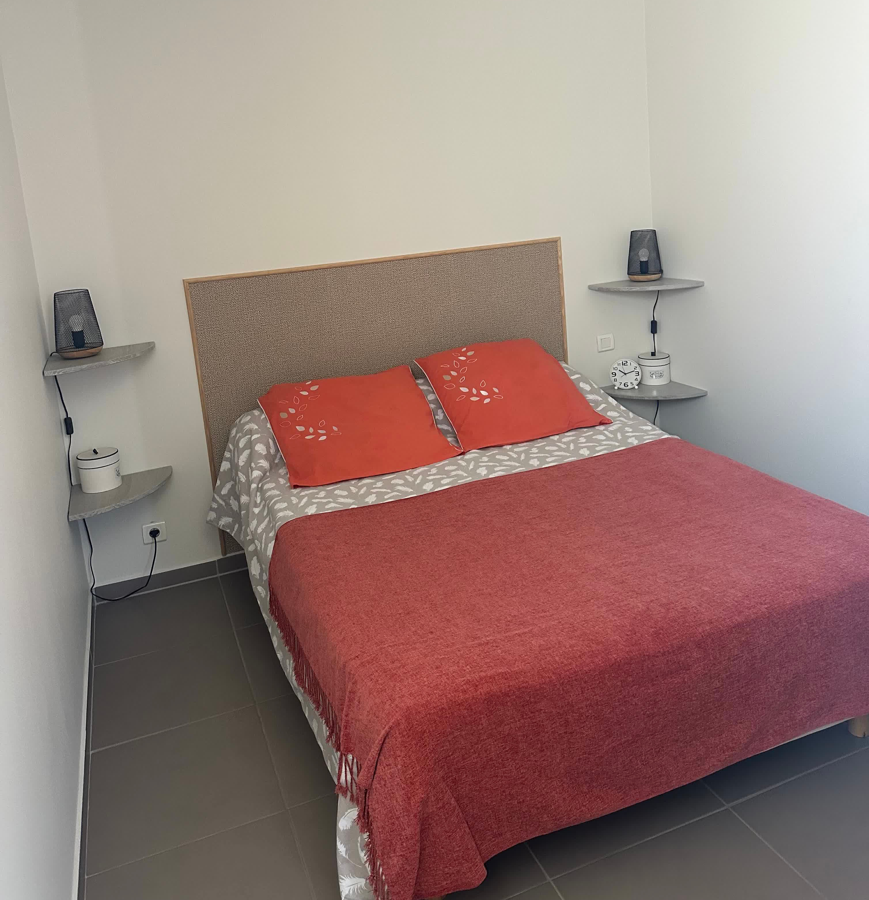 Chambre avec un lit double possédant des couvertures rouges