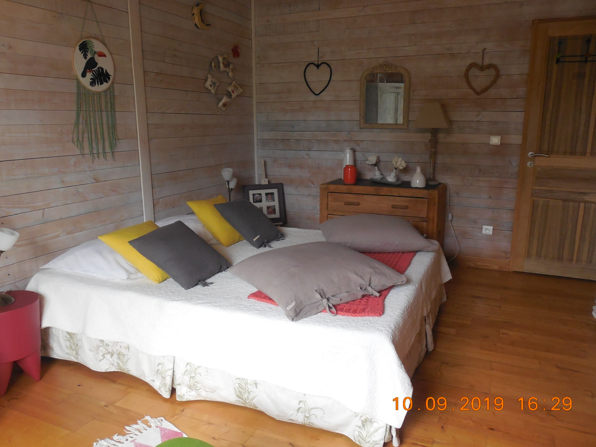 Chambre double spacieuse à l'ambiance chaleureuse, avec décoration en bois, grand lit confortable et parquet. Un espace lumineux et accueillant, idéal pour un séjour reposant à L'Isle-sur-la-Sorgue.  Ces descriptions sont optimisées pour une utilisation sur une fiche APIDAE : elles sont informatives, naturelles et évitent le bourrage de mots-clés tout en valorisant les principaux atouts de l'hébergement.