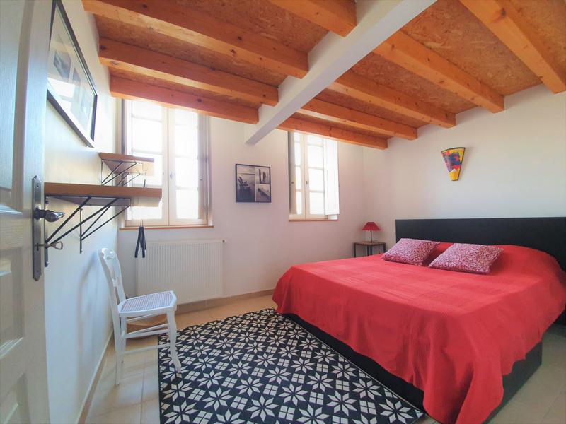 Chambre très lumineuse avec poutres en bois clair apparentes 