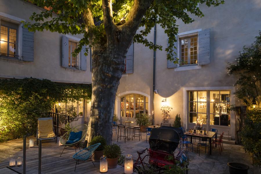 Cour interieure avec un platanes et une terrasse en bois.