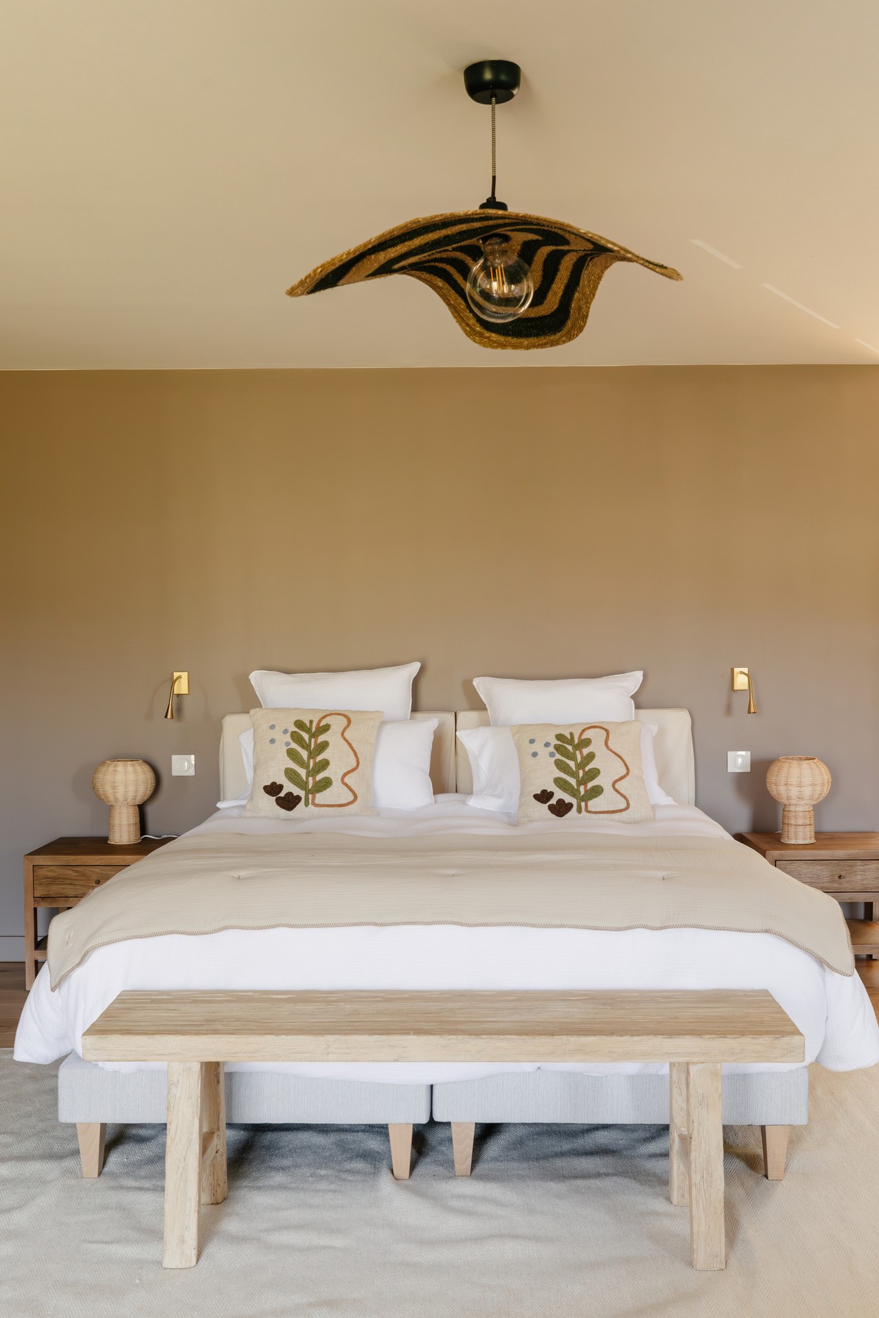 Une chambre élégante et apaisante aux tons naturels, où le bois clair, les matières tressées et la décoration minimaliste créent une ambiance chaleureuse et raffinée. Un cocon lumineux inspiré de l’art de vivre provençal.