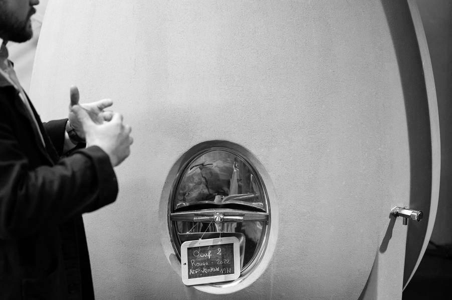 une personne sur la gauche donnant des explication devant un tonneau