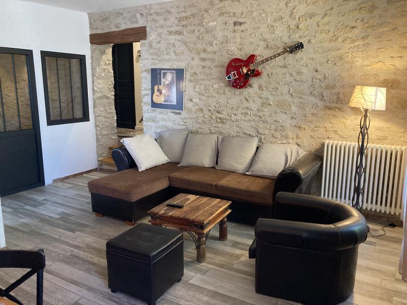 Salon avec mur en pierre et canapé en cuir 