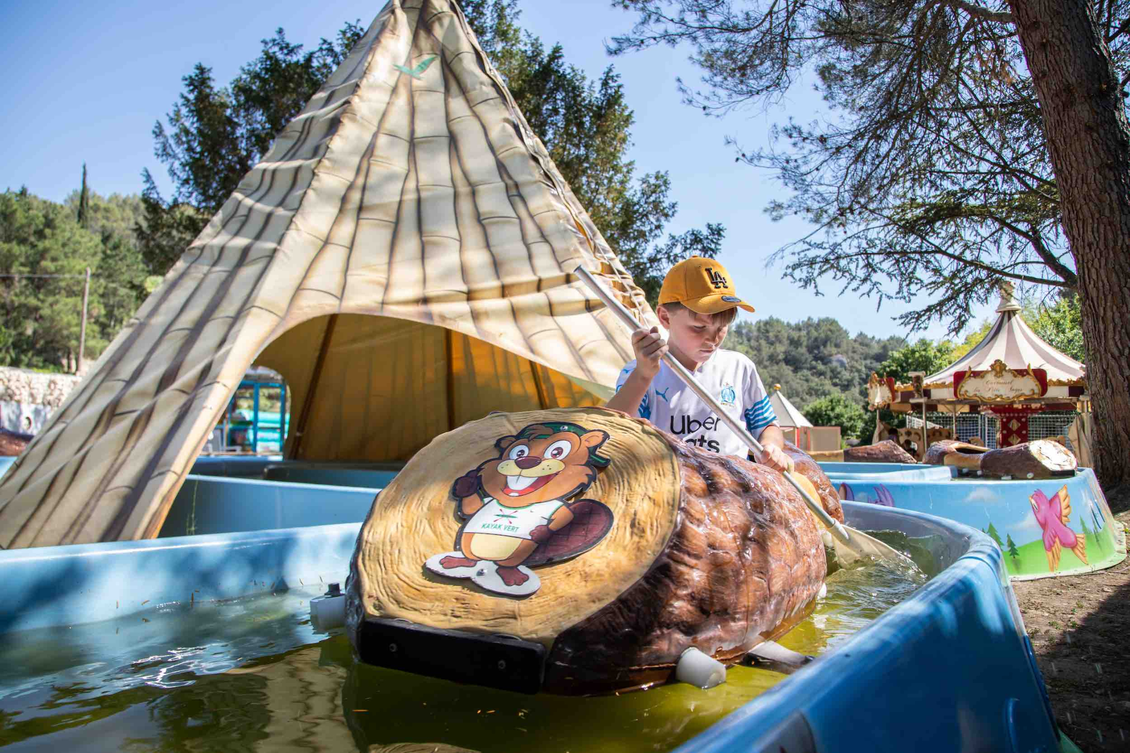 un enfant assis dans un rondin sur un parcours sur l'eau