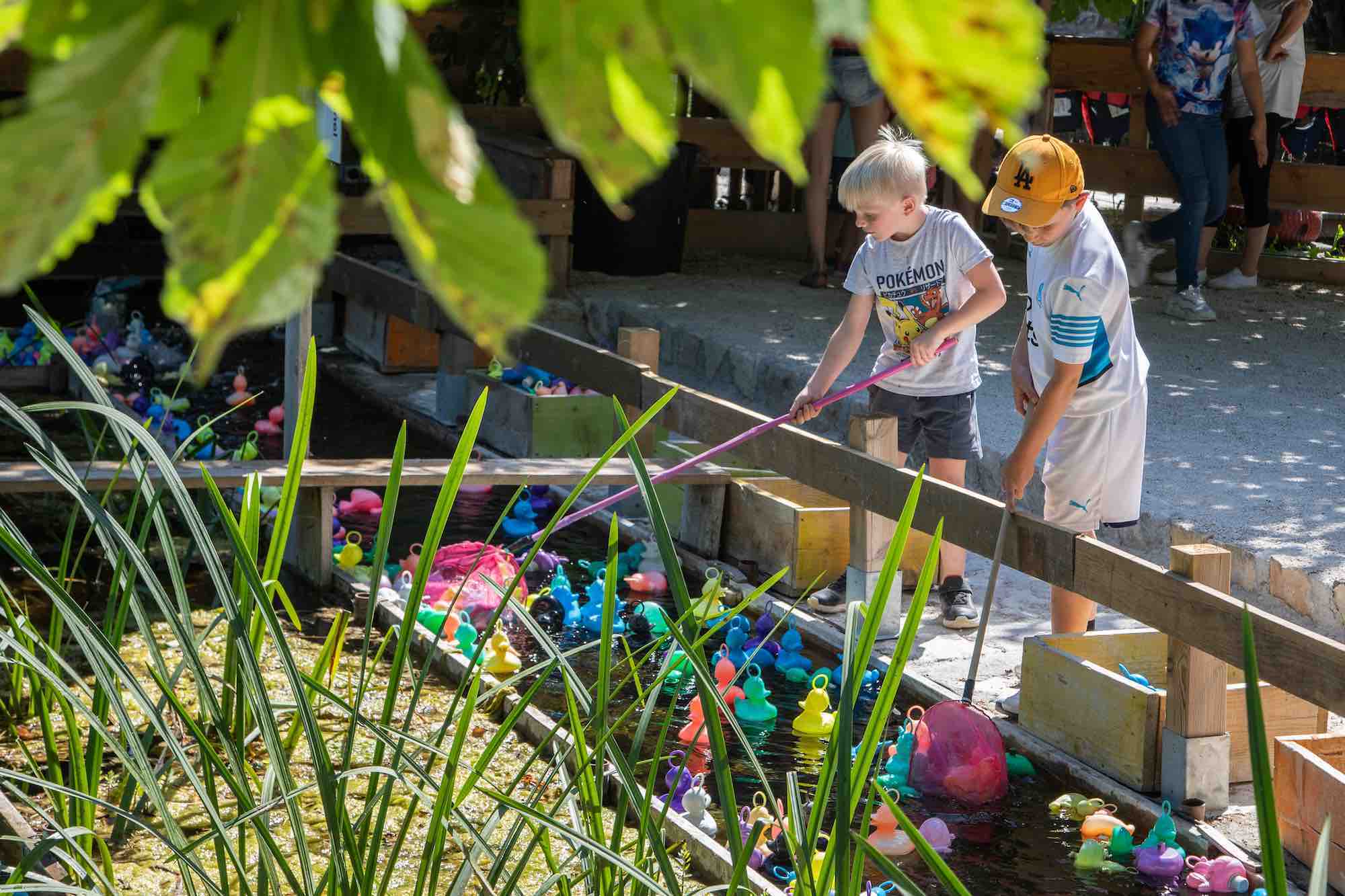  enfants en train de jouer à la pêche aux canards dans un cadre verdoyant