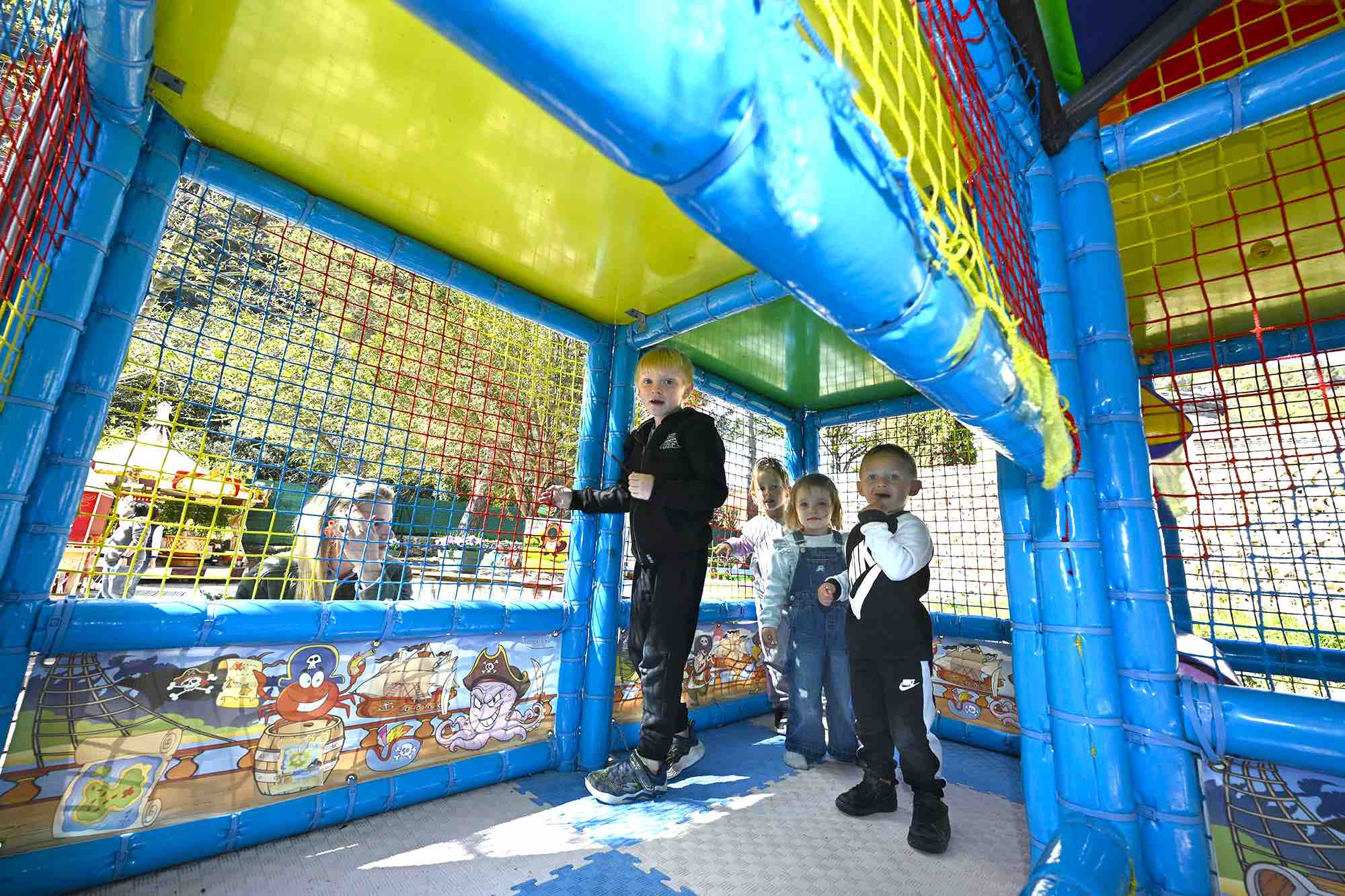  enfants jouant dans une structure labyrinthe bleu et jaune