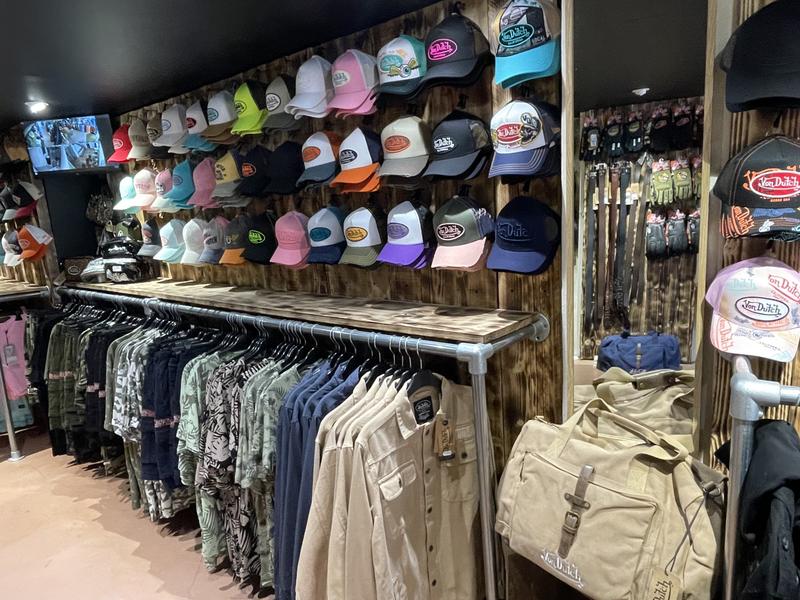 intérieur avec série de casquettes et rayonnage de chemise Von dutch