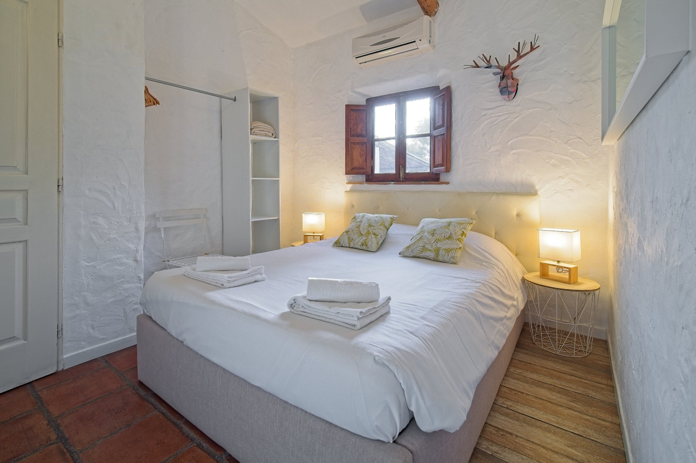 Chambre blanche avec un lit double 