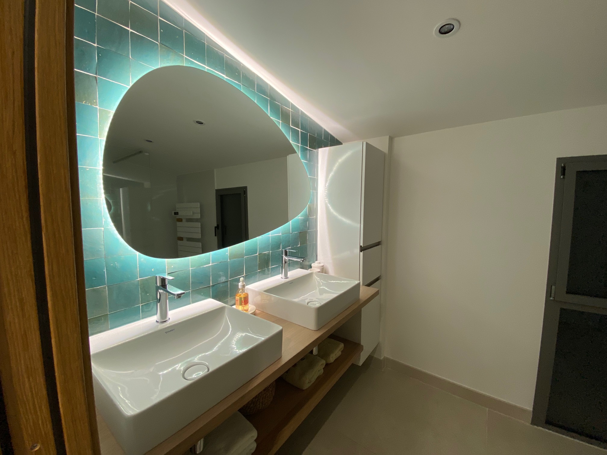 Salle de bain avec double vasque et miroir ovale 