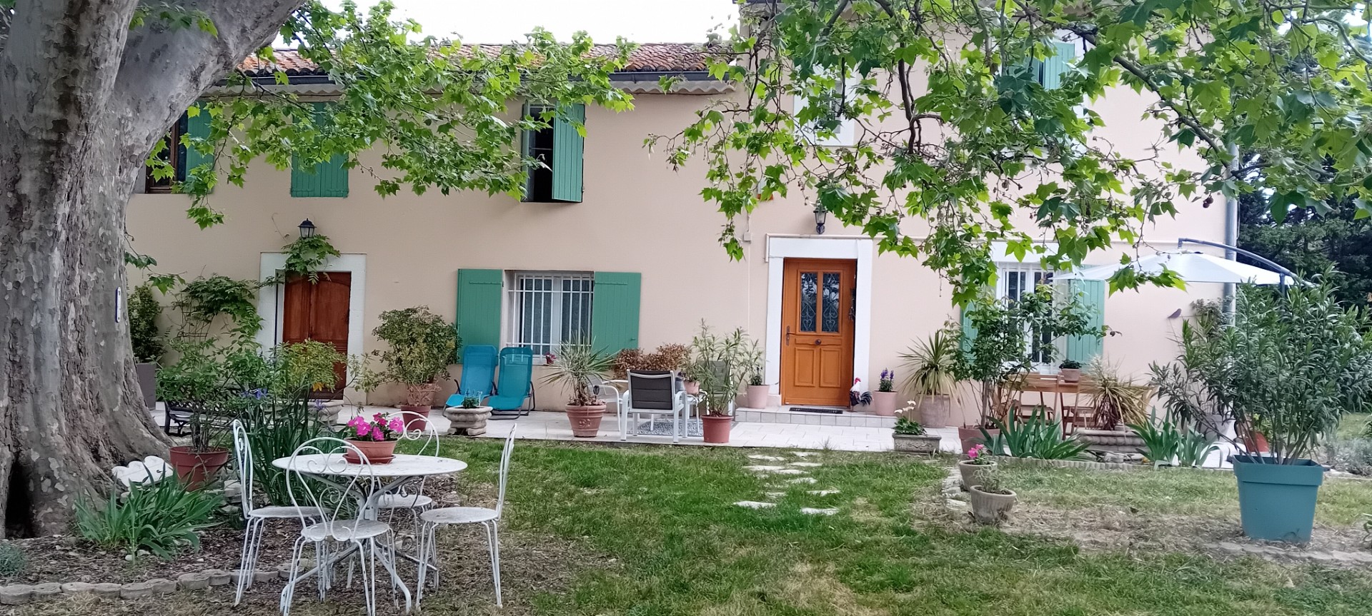 Une maison provençale entourée de verdure, avec jardin arboré, terrasse et espaces détente propices au calme et à la convivialité.