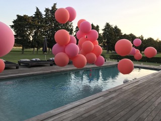 Piscine extérieure décorée pour une réception privée avec de nombreux ballons flottants et installés autour du bassin. Cette image illustre les prestations de surveillance de piscine proposées lors de mariages, anniversaires et événements privés.