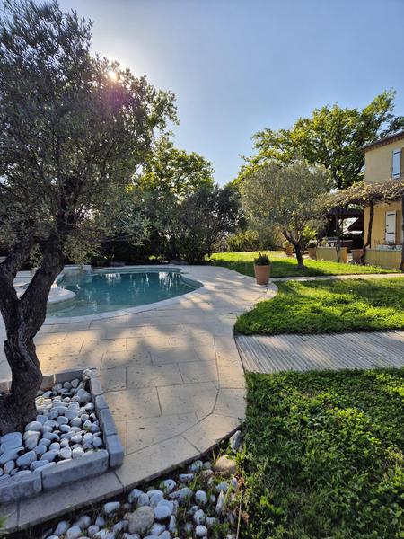 Vue extérieure d'une villa provençale entourée d'un jardin arboré avec piscine. Cette image illustre l'accompagnement proposé aux propriétaires de locations saisonnières pour valoriser leur bien et offrir un cadre de séjour attractif aux vacanciers.