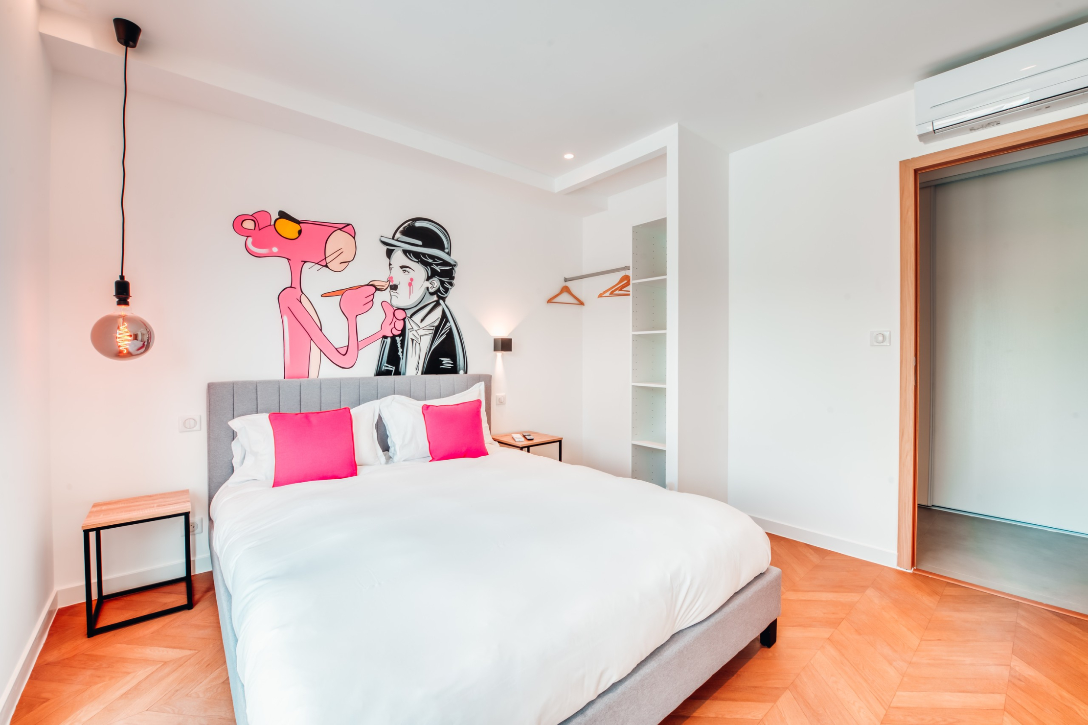 Chambre double climatisée à l’ambiance pop et décalée, décorée d’une grande fresque murale mettant en scène la Panthère Rose et Charlie Chaplin. Un espace lumineux et original.
