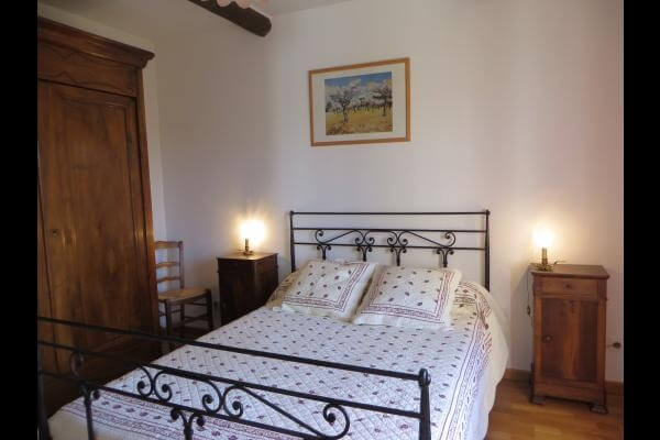 chambre avec un lit double, des meubles en bois et un carrelage typiquement provençale habillent la pièce