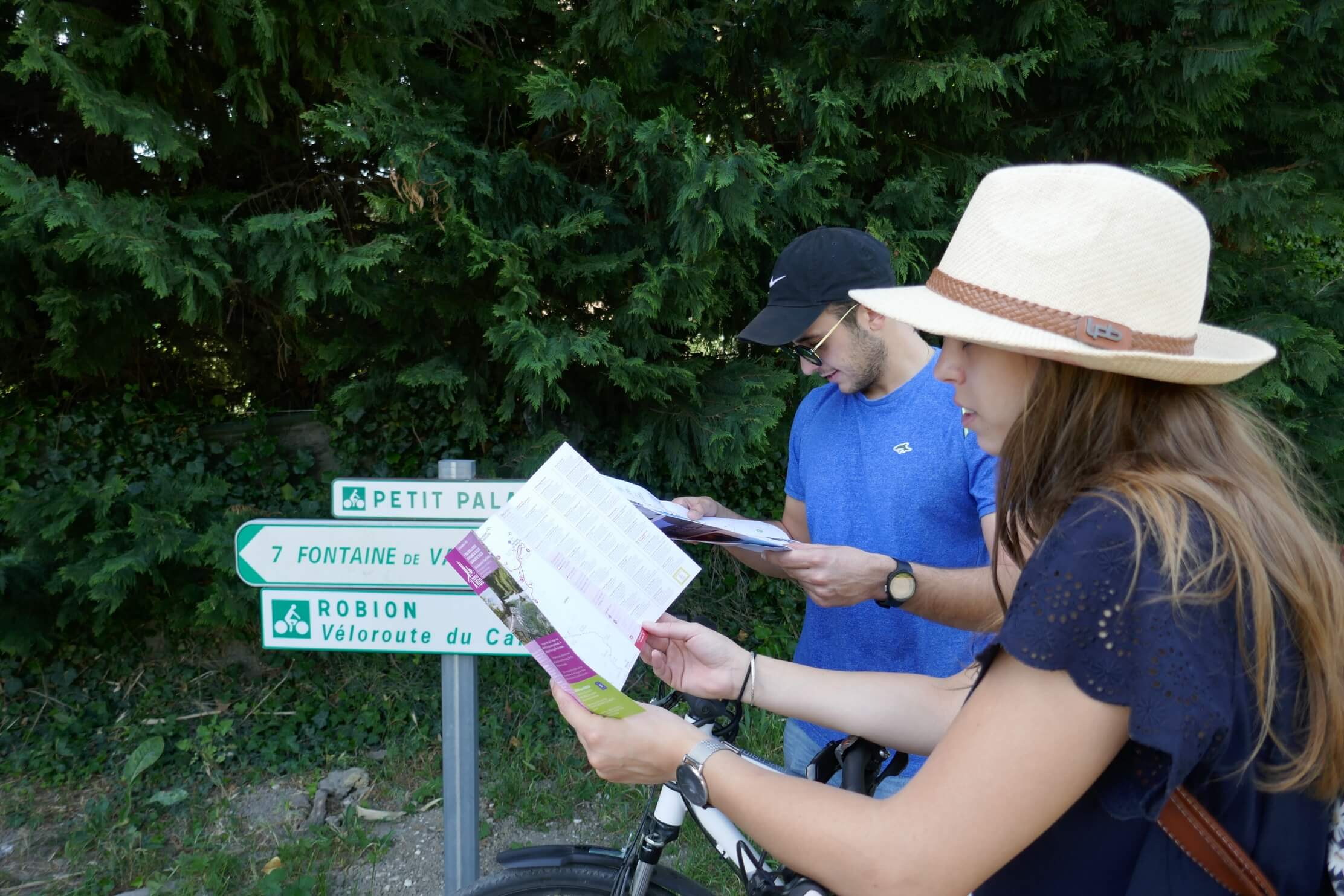 les deux cyclistes consultent de la documentation en rapport à leur parcours