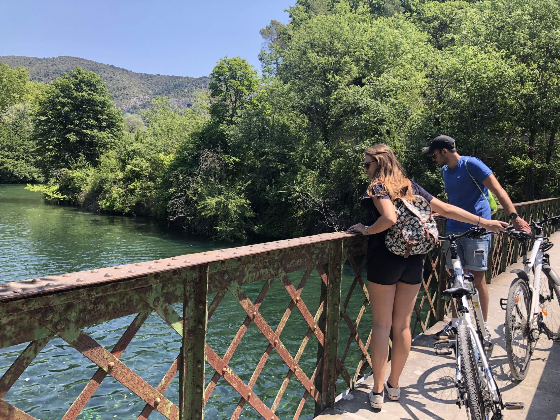 les deux cyclistes observent la Sorgue depuis un pont