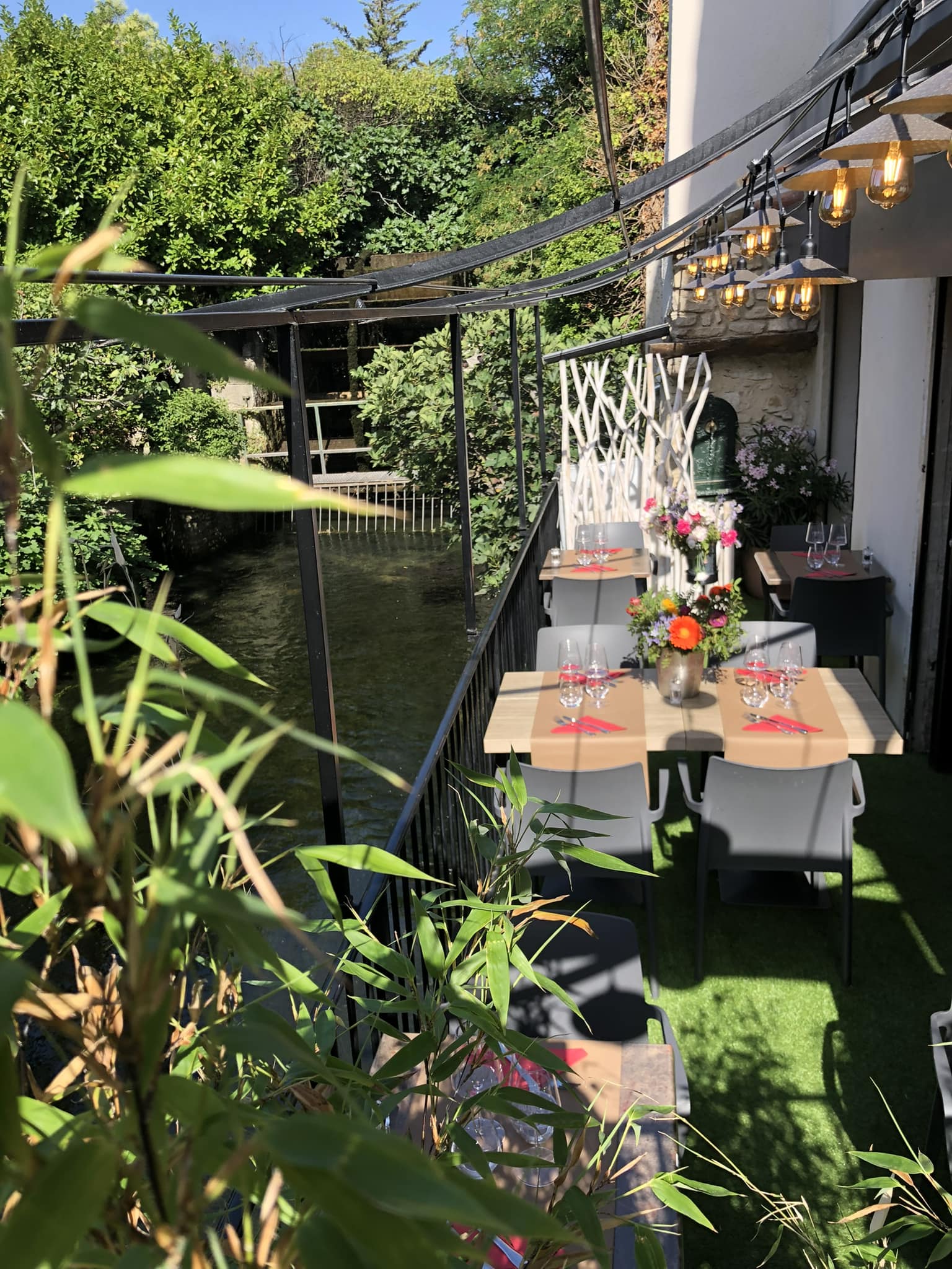 photographie de la terrasse en bord de Sorgue, avec une roue à aubes en arrière plan