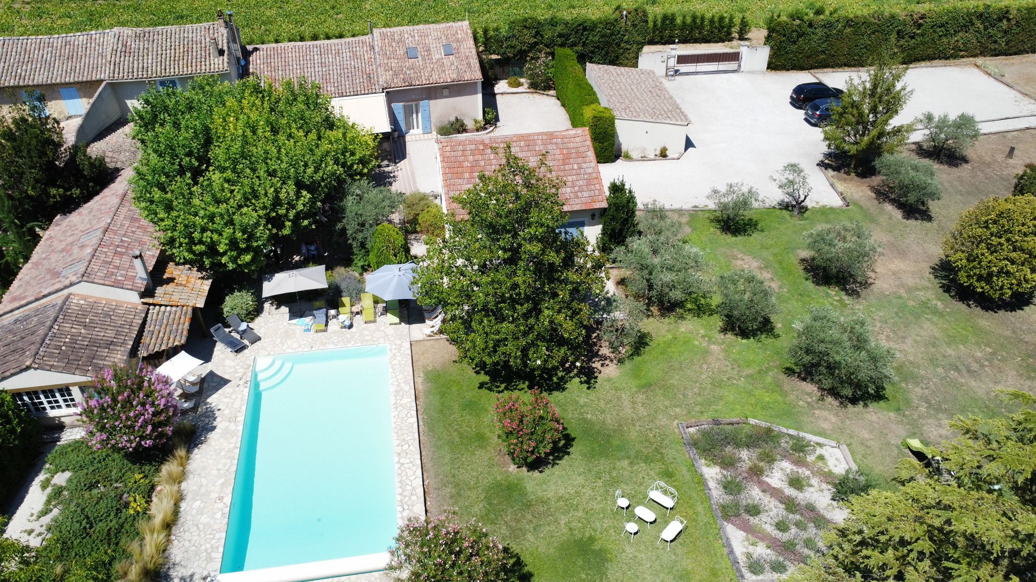 Une vue aérienne d'une propriété avec une piscine et plusieurs bâtiments entourés d'arbres et de verdure.